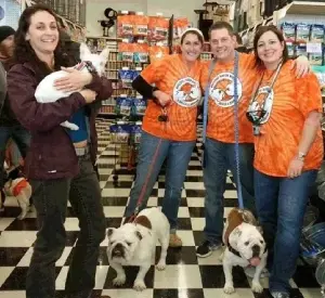 Four people and two dogs are posing for a picture.