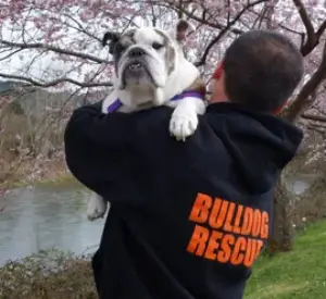 A man holding a dog in his arms.